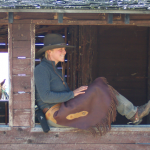 Angie Posing in Chaps - Yellowstone Horseback Riding Guides